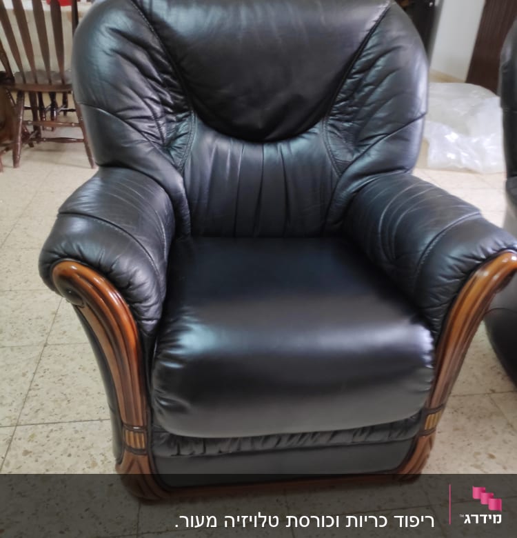 כורסה מרופדת בעור שחור עם מסגרת עץ
